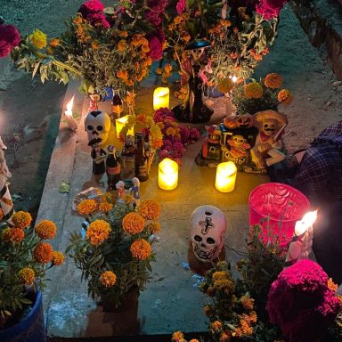 Autel coloré pour le Día de los Muertos avec fleurs, bougies et crânes décoratifs.