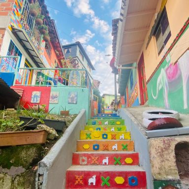 Escalier coloré menant à des maisons lumineuses dans un quartier animé.