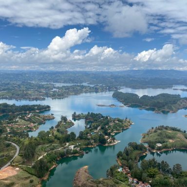 Vue panoramique de lacs, îles verdoyantes et ciel nuageux.